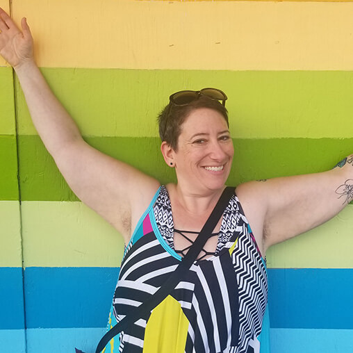 deb malkin body-positive massage therapist in front of striped wall