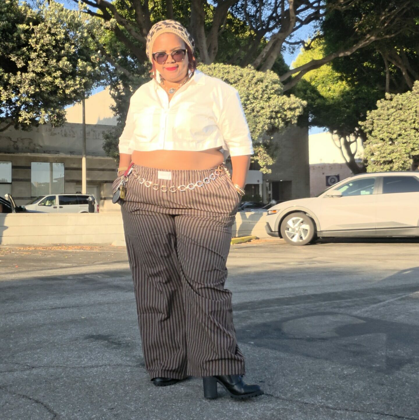 Tamara Mitchell wearing striped wide-leg trousers, a cropped white button-down shirt and black boots.